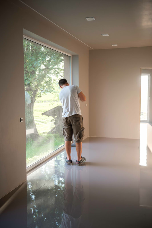Our crew member doing some concrete floor leveling work at a Burnaby home.